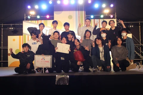 Participants posing for a group photo on stage