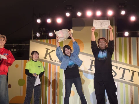 Participants holding award certificates on stage