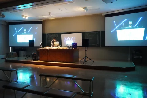 Music performance in a classroom with projected visuals and lighting