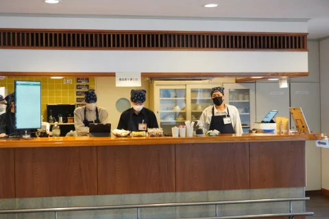 Cafe staff welcoming visitors at the counter
