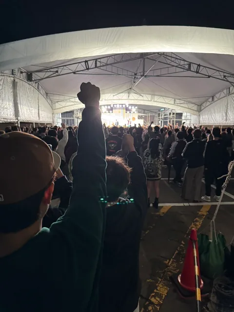 An audience enjoying a concert inside the stage tent at night
