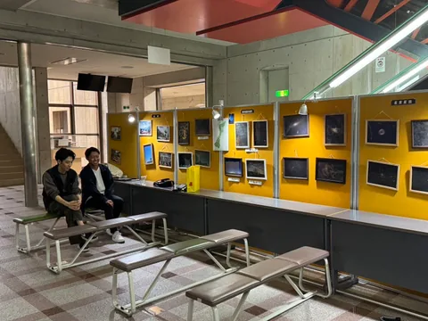 Students and framed photographs at a photography exhibition
